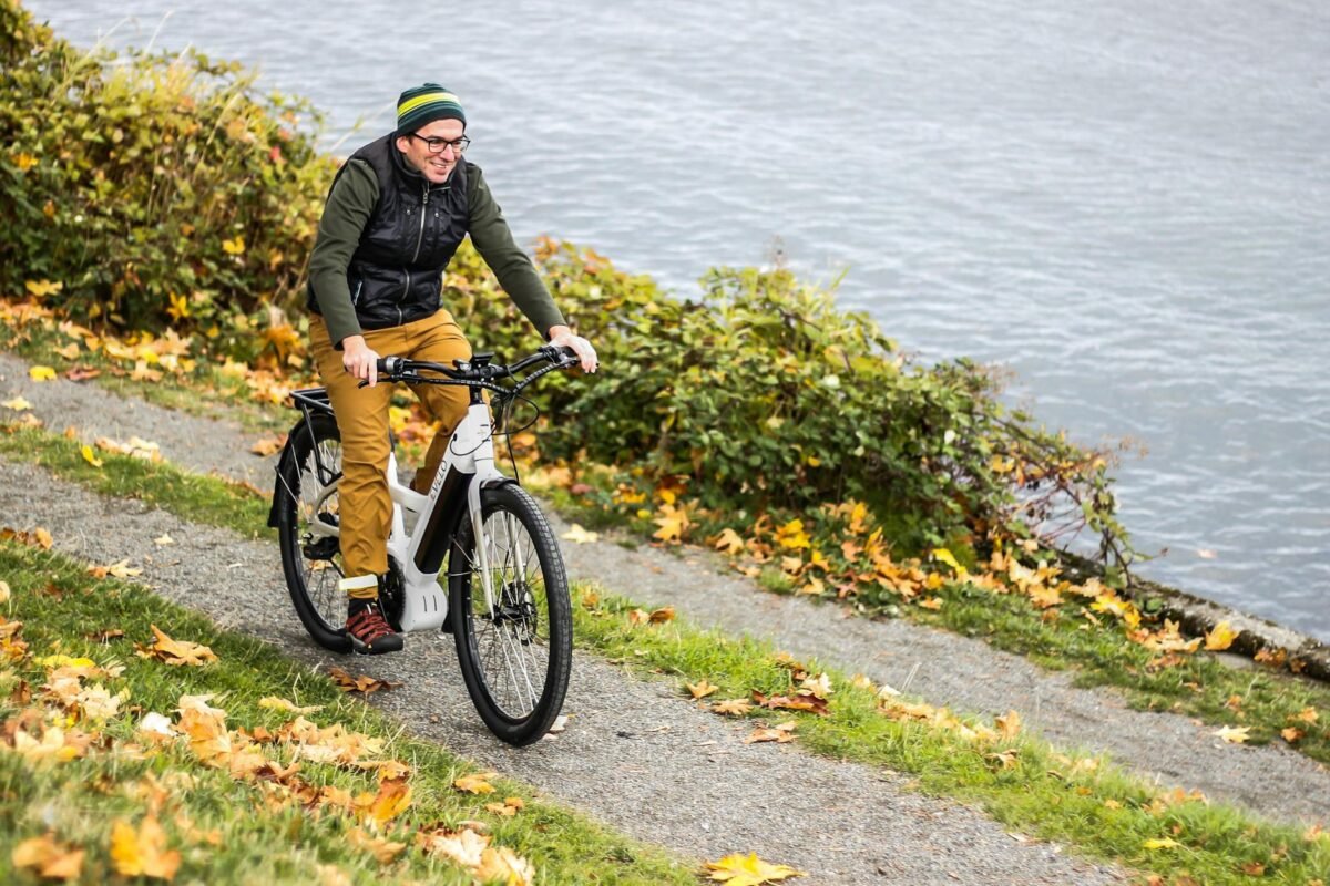 a man riding an electric bicycle by the river